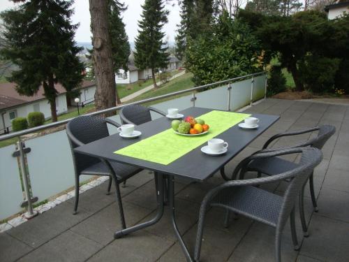 Exklusives Ferienhaus keine Monteure في Lichtenau: طاولة مع كراسي ووعاء من الفواكه على شرفة