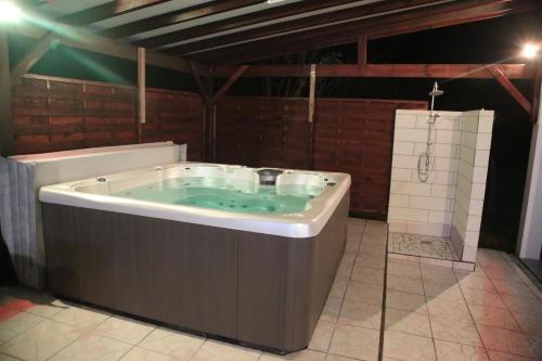 a large bath tub in a room at Joli bungalow avec jacuzzi chez Roberto in Petit-Canal