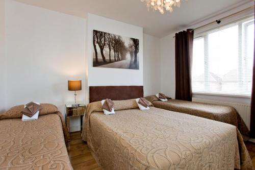 a bedroom with two beds and a window at Juzz Holiday Lets in London