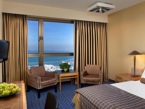 a hotel room with a bed and a large window at Dan Panorama Haifa Hotel in Haifa