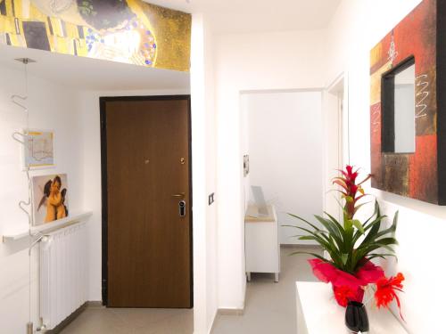 un pasillo con una puerta y una planta en un jarrón en B&B Ricci en Livorno