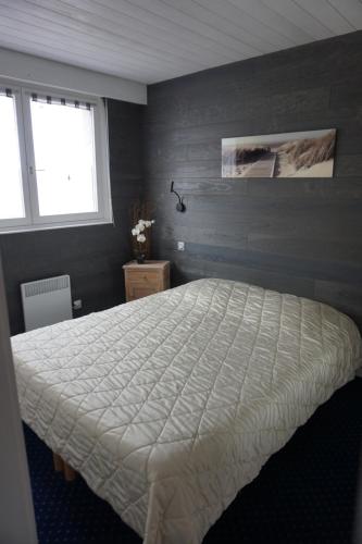 - une chambre avec un grand lit et une couette blanche dans l'établissement Le Grand Large, à Berck-sur-Mer