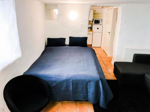 a bedroom with a blue bed and a couch at Boende Visby in Visby