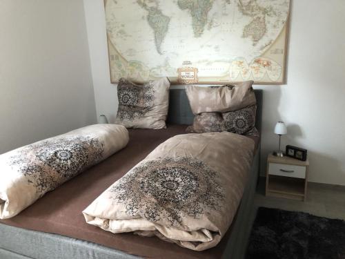 1 cama con 2 almohadas y un mapa en la pared en Ferienwohnung Anke - Apartement 1, en Hückelhoven