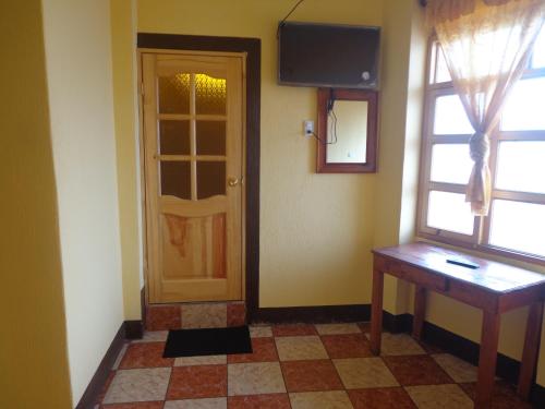 een kamer met een deur, een tafel en een raam bij Hotel Don Chema in San Pedro La Laguna