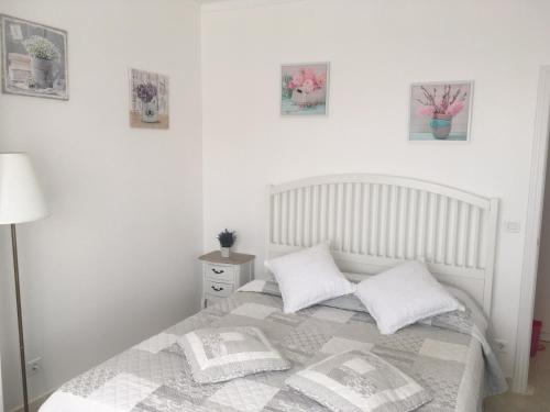 biała sypialnia z łóżkiem z 2 poduszkami w obiekcie Paradise w Costa de Caparica
