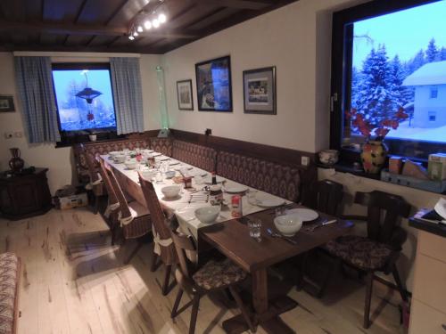 a dining room with a long table and chairs at Villa-Alpenblick in Hochrindl