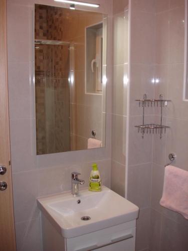 a bathroom with a sink and a shower with a mirror at Dominik in Orebić