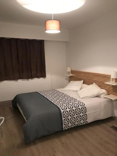 a bedroom with a large bed in a room at Hôtel du port in LʼAiguillon-sur-Mer