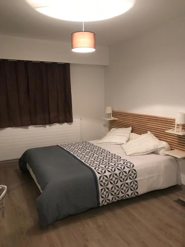 een slaapkamer met een groot bed in een kamer bij Hôtel du port in LʼAiguillon-sur-Mer