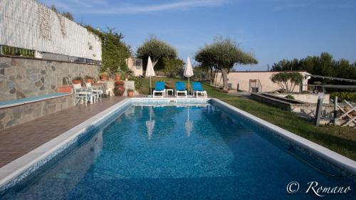 una piscina con sillas azules en Villa Montefontane, en Camporosso