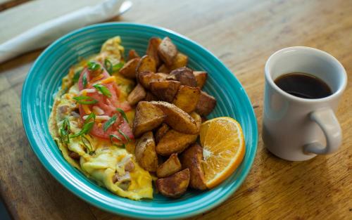 a plate of food with potatoes and a cup of coffee at Capt Hirams Resort in Sebastian