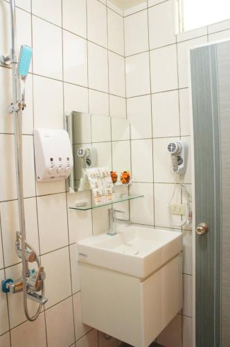 Un baño blanco con lavabo y espejo. en 芽哦小窩Ya OH Rooms, en Nangan