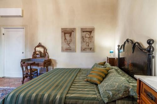 ピストイアにあるLocanda San Marco Residenza Caluriのベッドルーム1室(ベッド1台、テーブル、デスク付)