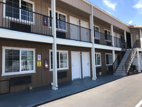 ein Gebäude mit weißen Türen und Treppen darauf in der Unterkunft Beachway Inn in Arroyo Grande