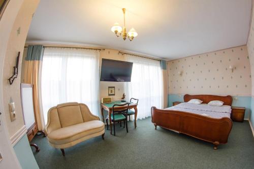 ヴウォツワヴェクにあるGarageHotelのベッドルーム1室(ベッド1台、椅子、テーブル付)