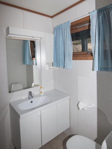 a bathroom with a white sink and a toilet at Grandane Feriehus in Stongfjorden