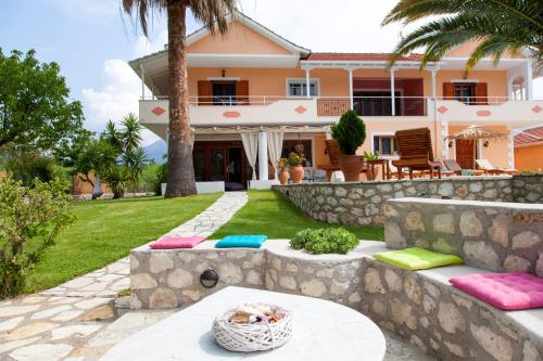 a house with a stone wall and a patio at Villa Aliki in Vasiliki