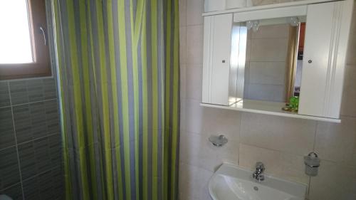 a bathroom with a shower curtain and a sink at Emma's Studios in Lassi