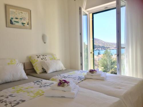 two beds in a room with a large window at Villa Salvia Adriatica in Grebaštica