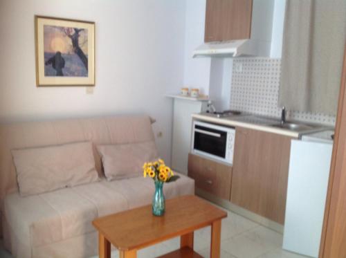 a living room with a couch and a table with flowers at Panorama in Skafidia