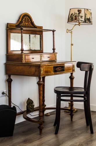 an antique desk with a chair and a mirror at Eleventh Floor Suites in Cagliari
