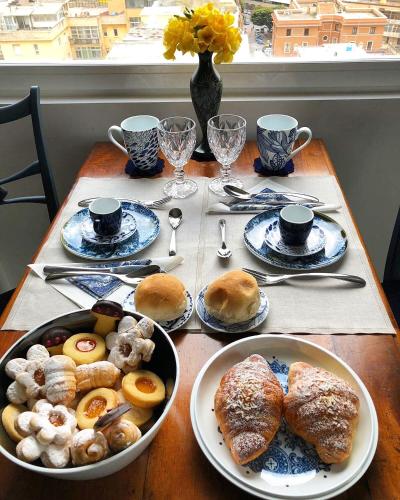 a table with plates of pastries and cups of coffee at Eleventh Floor Suites in Cagliari