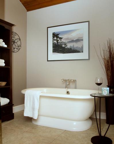 a bath tub in a bathroom with a picture on the wall at Coho Cottages in Willow Creek