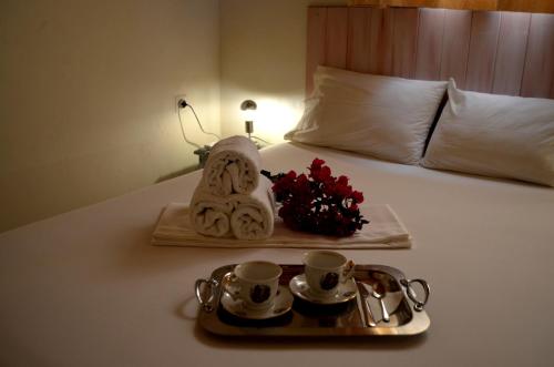 taca z 2 filiżankami herbaty i taca kwiatów na łóżku w obiekcie All Seasons House w mieście Liridhianá
