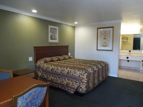 Castaway Motel في اورانج: غرفة الفندق بسرير وطاولة