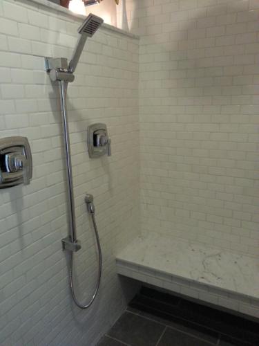 a bathroom with a shower with a bench in it at China Creek Cottages in Willow Creek