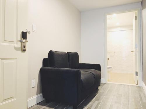 a black reclining chair in a room with a bathroom at Mayfair Inn and Suites in Queens