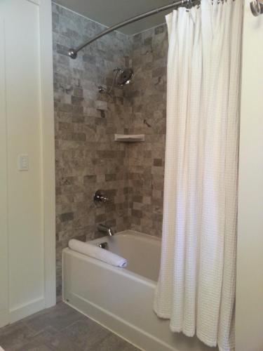 a bathroom with a bath tub with a shower curtain at China Creek Cottages in Willow Creek