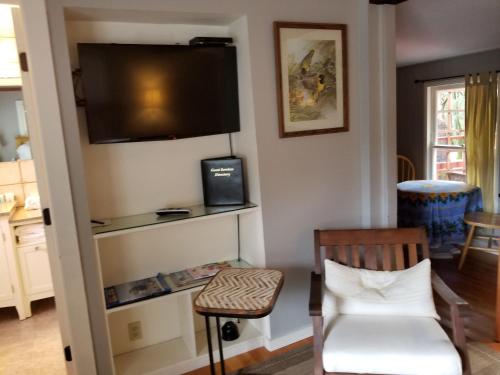 a living room with a chair and a television on the wall at China Creek Cottages in Willow Creek
