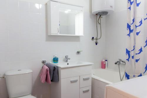 a bathroom with a sink and a toilet and a tub at Sunny Apartment in Belgrade