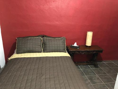 a bedroom with a bed and a red wall at Estancia del Sol in Cabo San Lucas