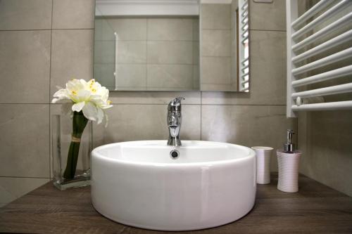 a white sink in a bathroom with a mirror and flowers at Stylish 2 Room Flat 60 meters to the beach in Nice