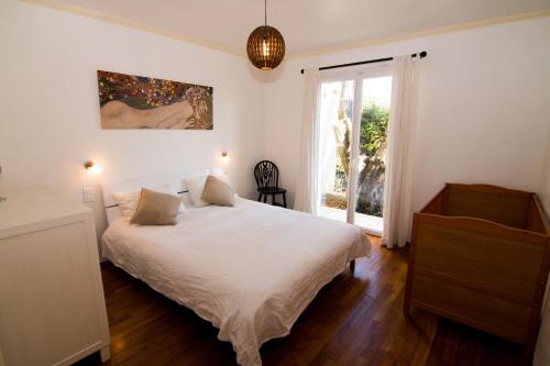 une chambre avec un lit blanc et une fenêtre dans l'établissement Villa Ad Alta, à Cannes La Bocca
