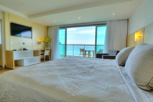 a hotel room with a large bed and a large window at Atlantico Sul Hotel in Rio de Janeiro