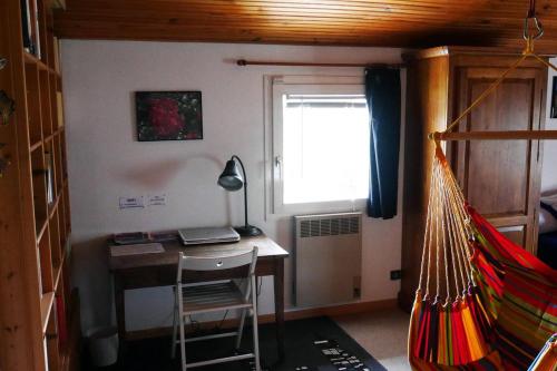 Habitación con escritorio, ventana y hamaca. en Chez Babeth, en Toulouse