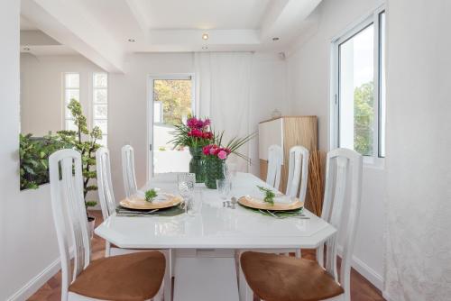 a white dining room with a white table and chairs at Susy’s Garden in Funchal