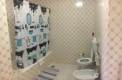 een badkamer met een toilet en een douchegordijn bij Apartamento T1 Quinta Nova - Alvor in Alvor