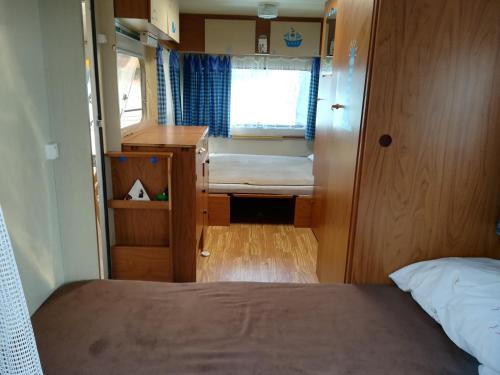 a small room with a bed and a window at Caravan near the sea 2 in Ugljan