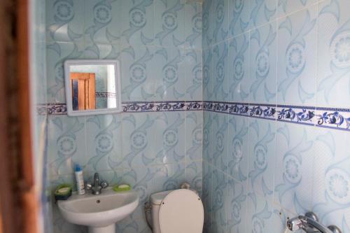 Baño azul con lavabo y aseo en Laverie du Soleil Surf House, en Taghazout