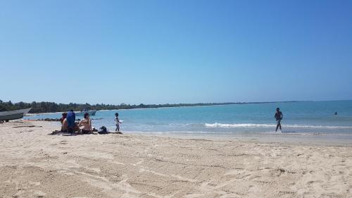 a group of people sitting on the beach at Hostel Beach House in Rincón
