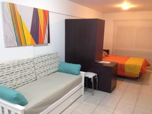 Dormitorio con cama, banco y pintura en Las Marinas Rent en Bahía Blanca