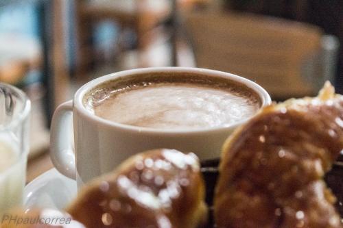 une tasse de café et quelques beignets sur une assiette dans l'établissement Hotel Vial Center, à Mar del Plata