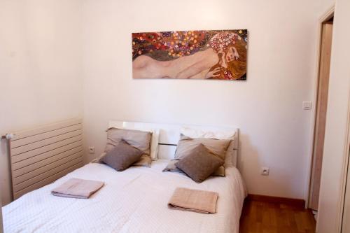 een slaapkamer met een bed met een schilderij aan de muur bij Villa Carpe Diem in La Roquette-sur-Siagne