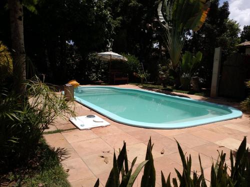 a swimming pool in a yard with an umbrella at Suíte Bella Vista in Barra Grande