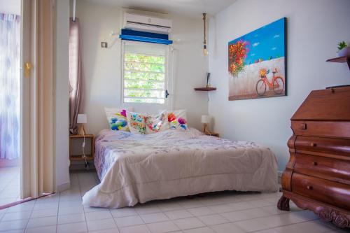 a bedroom with a bed and a window and a dresser at Ti' Paradis in Terre-de-Haut